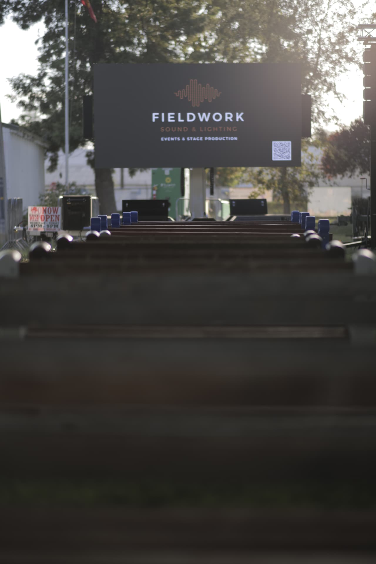 Fieldwork Sound & Lighting LED screen displaying the company logo at an outdoor event before opening